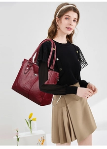 Detailansicht der großen dunkelroten Shopper-Tasche mit Knitteroptik und Metallbeschlägen