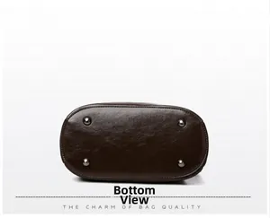Detailed bottom view of dark brown leather crossbody bag with four protective metal studs