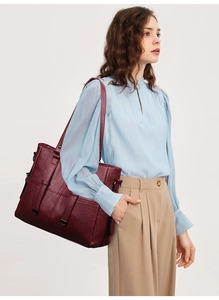 Vue détaillée d'un sac cabas bordeaux avec texture grainée rétro et boucle décorative