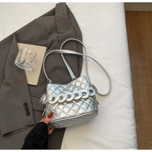 Detailed view of silver quilted crossbody bag with diamond studs and bold chain