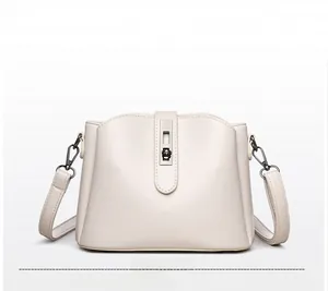 Detail of cream white leather bucket bag with metallic lock and dark gray metal hooks