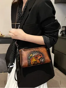 Detail of vintage brown leather crossbody bag featuring colorful embossed elephant pattern