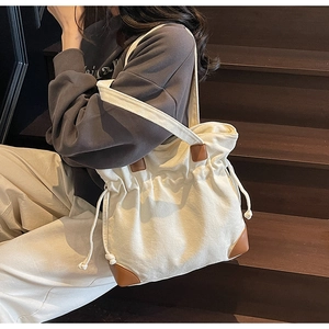 Détail du sac fourre-tout en nylon blanc cassé avec accents en cuir marron et cordon