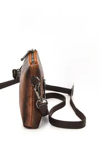 Detail of vintage brown textured leather crossbody bag with detachable strap and hook