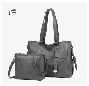 Détail de l'ensemble sac cabas et pochette bandoulière en cuir gris foncé mat avec ferrures