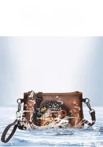 Detail of waterproof brown leather crossbody bag with embossed elephant design and splash effect