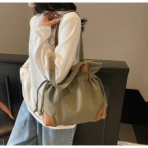 Détail du sac seau en nylon vert armée avec coins en cuir marron et fermeture à cordon