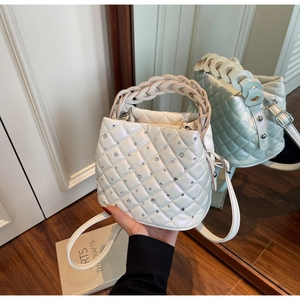 Detail of white quilted handbag with crystal rhinestones and woven top handle