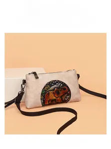 Detail of vintage embossed elephant pattern and leather texture on a beige crossbody bag