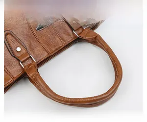 Detail der braunen Kunstleder-Tasche mit robustem Rundgriff und silbernem D-Ring-Beschlag