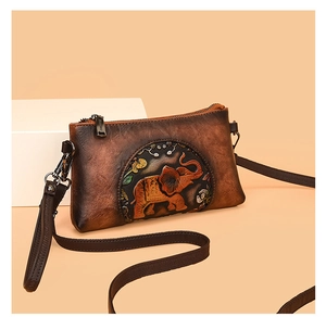 Macro detail of brown leather envelope bag featuring 3D embossed elephant and floral patterns