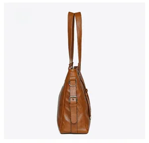 Vue latérale du sac fourre-tout vintage en cuir marron avec bandoulières réglables et boucles