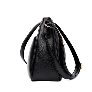 Classic black leather crossbody bag with lychee texture and gold-tone hardware side view