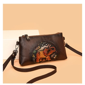 Detail of vintage brown leather bag with ethnic elephant embossing and gunmetal hardware