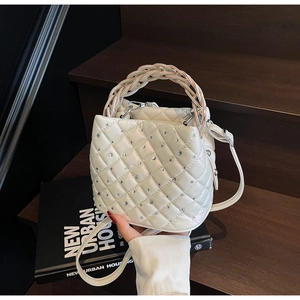 Detail of quilted diamond pattern and silver rhinestones on cream white bucket bag