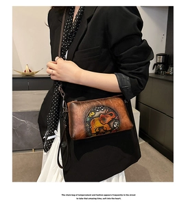 Close-up of vintage brown leather bag featuring an embossed elephant and hand-painted detail