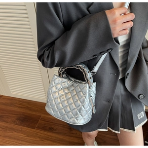 Macro shot of silver diamond-quilted handbag with rhinestones and woven handles