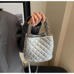 Close-up of silver quilted bucket bag with shimmering rhinestones and thick chain handle