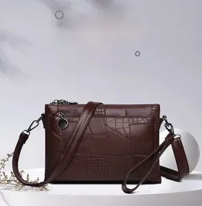 Detail of dark brown crocodile texture PU leather crossbody bag with triple zip layers