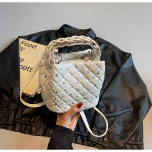 Close-up of white quilted bucket bag with rhinestone details and woven handle