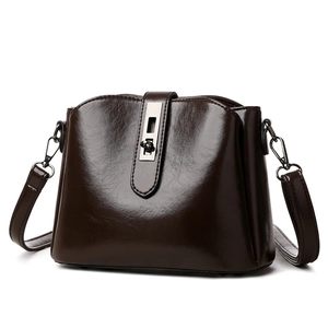 Retro dark brown glossy leather crossbody bag with silver buckle on white background