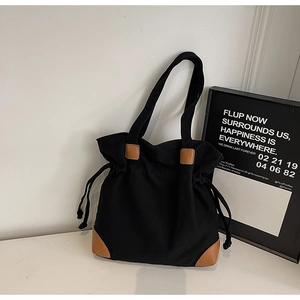 Détail du grand sac cabas en nylon noir avec cordon et finitions en cuir marron