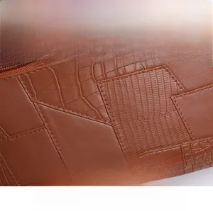 Macro detail of brown patchwork faux leather with crocodile and lychee textures