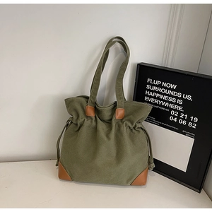 Gros plan du sac fourre-tout en nylon vert militaire avec renforts en cuir marron