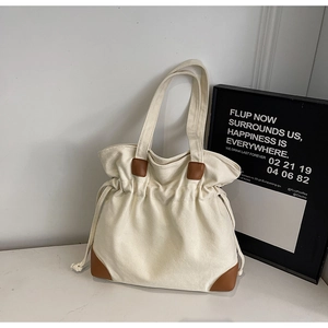 Detail of minimalist nylon tote with leather corners and functional drawstring closure