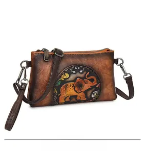 Detail of vintage brown leather bag with embossed elephant pattern and strap