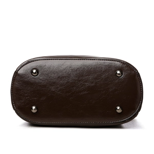 Minimalist dark brown leather bucket bag bottom view with silver metal feet and stitching