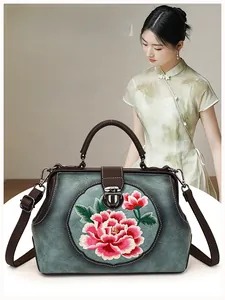 Detail of floral peony embroidery on vintage style grey leather Chinese handbag