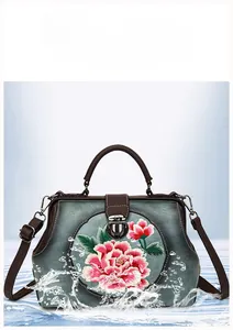 Detailed close-up of pink peony embroidery on retro grey leather handbag with water splashing