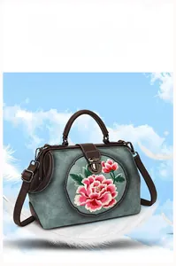 Detail of floral peony embroidery on vintage green faux leather handbag with doctor bag clasp