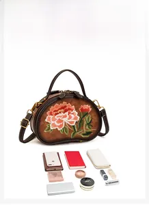 Detail view of round leather crossbody bag showing large capacity for phone and cosmetics