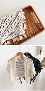 Détail du châle en tricot ajouré avec glands à franges en beige et noir