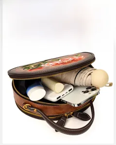 Interior view of brown round crossbody bag showing large storage for daily essentials