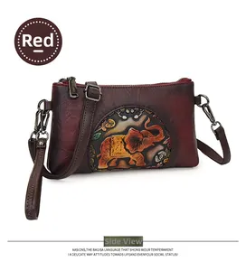 Detail of red embossed elephant pattern on soft leather envelope crossbody bag