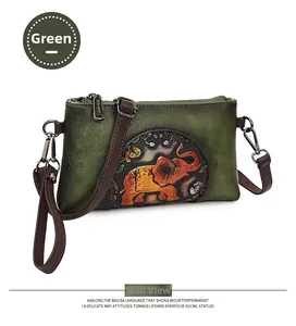 Detail of green retro envelope bag featuring a vintage orange elephant embossed pattern