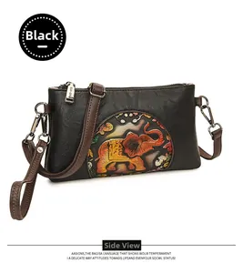 Detail of colorful elephant embossed pattern on black faux leather handbag with hardware