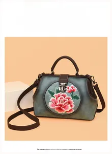 Close-up of pink peony embroidery and vintage metal clasp on a retro doctor bag