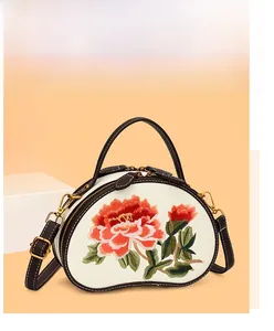 Close-up of exquisite peony embroidery detail on a vintage cream crossbody handbag