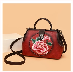 Close-up of red Chinese peony embroidery and retro doctor bag metal buckle detail