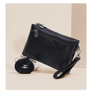 Detail view of black textured PU clutch bag with multi-zipper compartments and straps