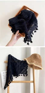 Détail du châle ajouré au crochet noir avec glands et texture de dentelle tissée