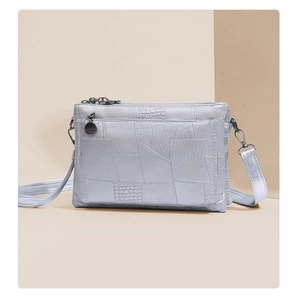 Detail view of silver PU envelope bag with mixed faux crocodile and lizard leather textures