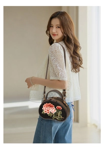 Close-up of vintage oval handbag with peony embroidery and gold metal details