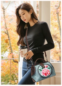 Detail of doctor bag with peony embroidery and leather trim shown in autumn street setting