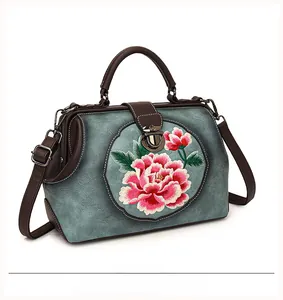 Detailed embroidery of pink peony on blue leather vintage handbag with bronze clasp