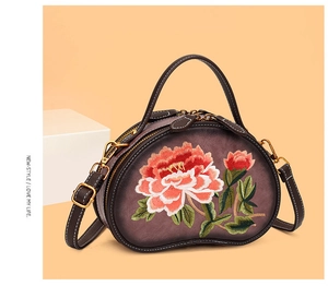 Detail of peony embroidery on a purple leather handbag with vintage bronze hardware